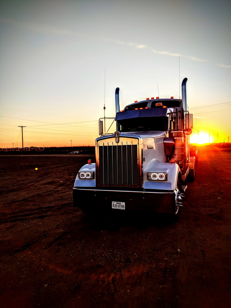 Semi truck at sunset in oil field